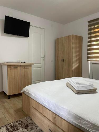 a bedroom with a bed and a tv on the wall at Casa Milla in Sovata