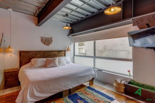- une chambre avec un lit et une grande fenêtre dans l'établissement Cozy & Vibrant Loft with Rooftop & Gym in Polanco, à Mexico