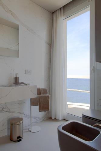 a bathroom with a sink and a large window at Hotel Sans Souci in Gabicce Mare