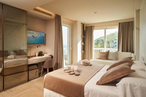 a hotel room with a bed and a desk and a window at Hotel Sans Souci in Gabicce Mare