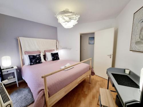 um pequeno quarto com uma cama com uma estrutura em madeira em Coquette maison de ville calme avec patio em Angoulême