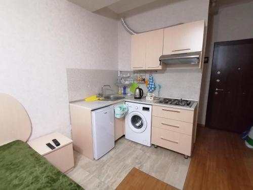 a small kitchen with a washing machine and a washer at Квартира in Baku