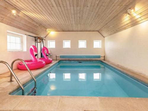 uma piscina interior com insufláveis cor-de-rosa num quarto em 8 person holiday home in Bl vand em Blåvand