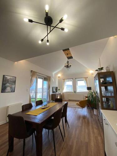 a living room with a dining room table and chairs at Hillside Apartman in Dunaszentmiklós