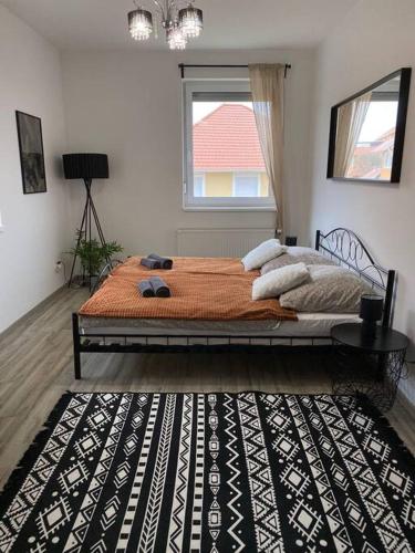 a bedroom with a bed with a black and white rug at Hillside Apartman in Dunaszentmiklós