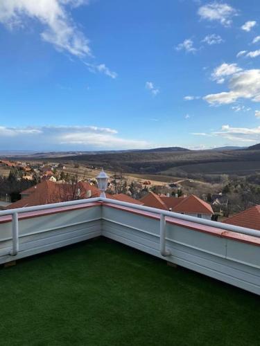 a white balcony with a view of a city at Hillside Apartman in Dunaszentmiklós