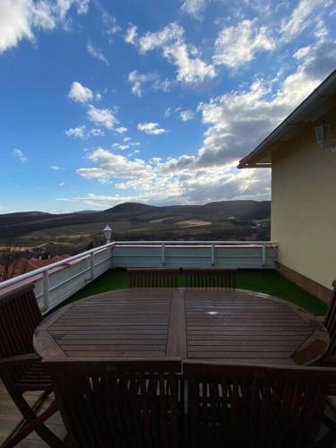 a deck with two chairs and a table on a balcony at Hillside Apartman in Dunaszentmiklós