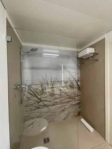 a bathroom with a shower with grass on the wall at Appartment bezaubernder Landblick in Timmendorfer Strand