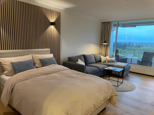 a bedroom with a large bed and a couch at Appartment bezaubernder Landblick in Timmendorfer Strand