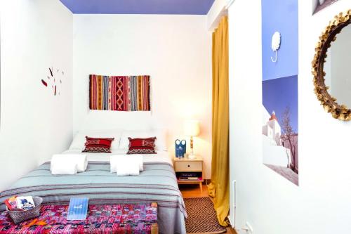 1 dormitorio con cama y espejo en Sweet Inn - Atic Eloi, en Barcelona