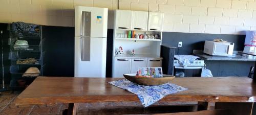 奧蘭布拉的住宿－POUSADA Chacara ENTRE NÓS，厨房配有木桌和碗