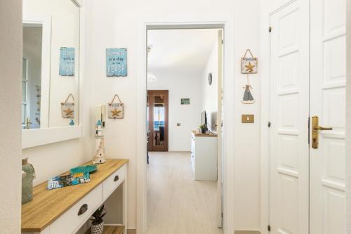 un pasillo con paredes blancas y una puerta blanca en Appartamento Ogliastra, en Santa Maria Navarrese