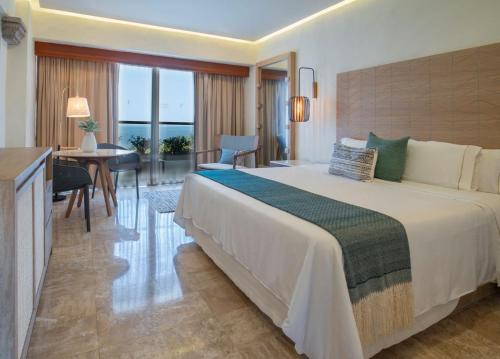 um quarto de hotel com uma cama grande e uma secretária em Fiesta Americana Puerto Vallarta All Inclusive & Spa em Puerto Vallarta