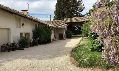 a house with purple flowers on the side of it at Phèdre en Saône in Genouilleux