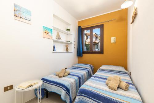 a room with three beds with towels on them at Appartamento Ogliastra in Santa Maria Navarrese