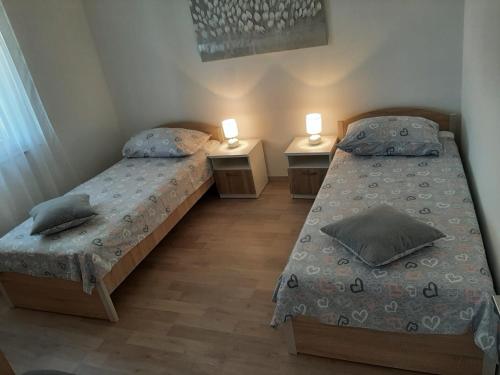 - 2 lits dans une chambre avec 2 tables de nuit et des lampes dans l'établissement Apartment By The Sea Marko, à Banj
