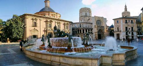 a fountain in a courtyard in front of a building at PLAZA HOME in Valencia