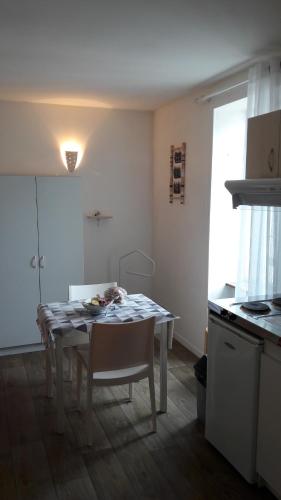Studio 20 m2-Proche gare في لا روش سور يون: مطبخ مع طاولة وطاولة وكراسي