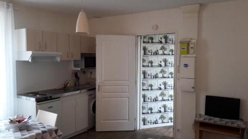 Studio 20 m2-Proche gare في لا روش سور يون: مطبخ مع ثلاجة مليئة بالأطباق