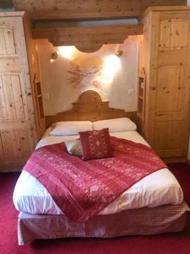a bedroom with a large bed with a wooden headboard at Hôtel la Kinkerne in Morzine