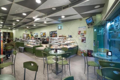 a restaurant with tables and chairs and a counter at WEAA Hotel in Nazaré