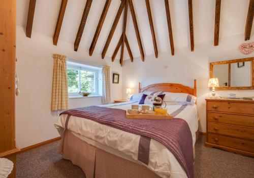 a bedroom with a bed with a mirror and a dresser at The Maltings in Ludham
