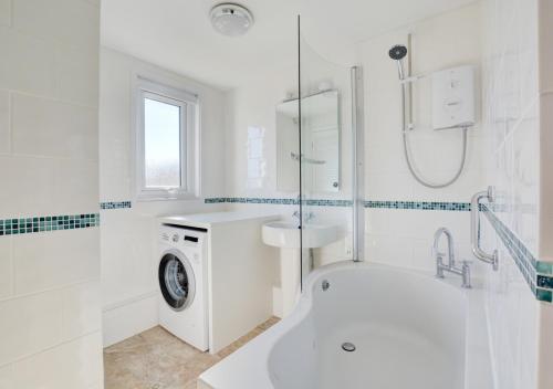 a white bathroom with a sink and a washing machine at The Lookout -Cromer in Cromer