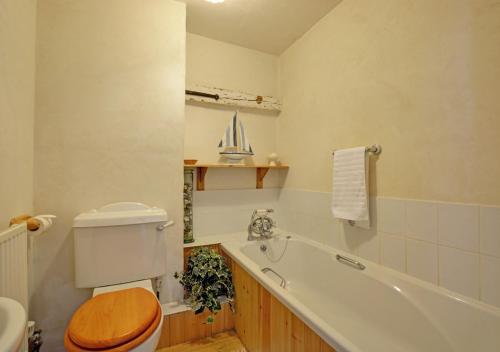 a bathroom with a toilet and a bath tub at The Old Coach House in Cawston