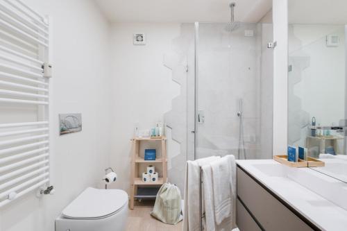 een witte badkamer met een toilet en een douche bij Sweet Inn - Porta Romana in Milaan