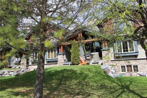 a large house with a lawn in front of it at Pinnacle Ridge Condos by Fernie Central Reservations in Fernie