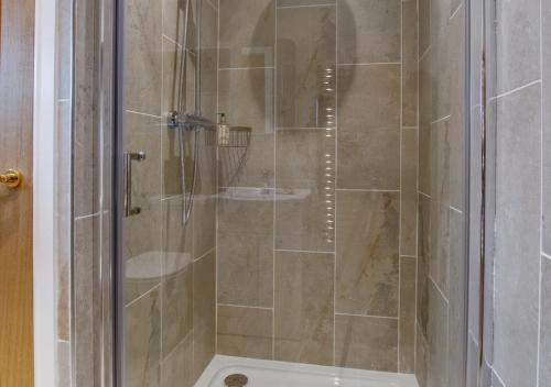 a shower with a glass door in a bathroom at The Old School House in Reepham