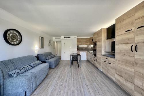 un salon avec un canapé bleu et une cuisine dans l'établissement Nice studio with balcony located in Fréjus, à Fréjus