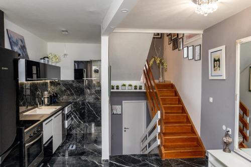 uma cozinha com piso em mármore preto e uma escadaria em Art & Gallery Vacation Home em Korčula