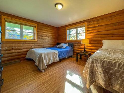 a bedroom with two beds in a log cabin at Elkhorn 3 Bedroom 2 Bathroom Log Cabin Sleeps 8 - Lincoln Log Cabin in Elkhorn