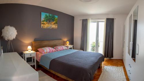 1 dormitorio con 1 cama con 2 mesas y una ventana en Art & Gallery Vacation Home en Korčula