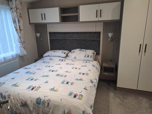 a bedroom with a bed with a large bedspread with animals on it at Withernsea luxury caravan hire in Waxholme