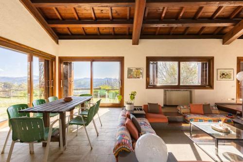 a living room with a table and green chairs at Oasi di Mastarone - Il vino e le Rose in Momperone