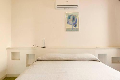 a bed in a white room with at Oasi di Mastarone - Il vino e le Rose in Momperone