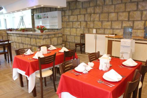 a restaurant with red tables and chairs and a kitchen at Hotel Gold Stone in Beldibi