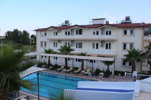 a hotel with a swimming pool in front of a building at Hotel Gold Stone in Beldibi