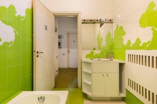 a green bathroom with a sink and a toilet at Oasi di Mastarone - Il vino e le Rose in Momperone