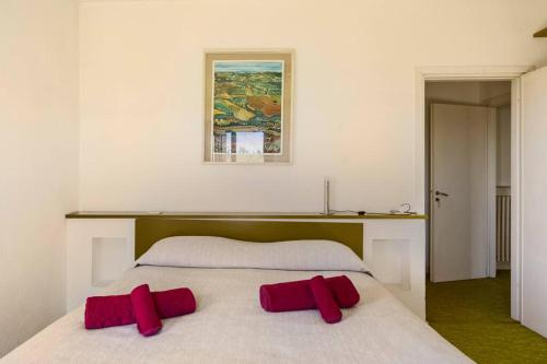 a bedroom with a bed with two red pillows on it at Oasi di Mastarone - Il vino e le Rose in Momperone