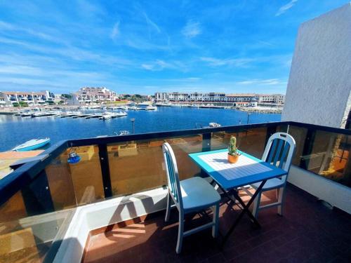 een balkon met een tafel en stoelen en uitzicht op een haven bij Le bonheur entre Lac et Mer in Le Barcarès