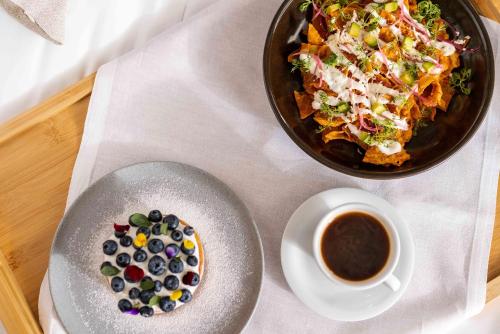 een tafel met een bord eten en een kopje koffie bij Mondrian Mexico City Condesa in Mexico-Stad