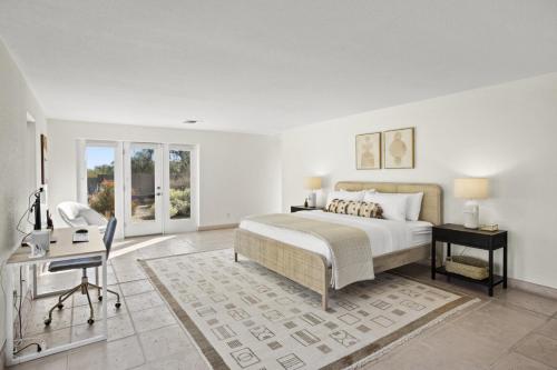 a white bedroom with a bed and a desk and a chair at A WFH Resort in Paradise Valley in Scottsdale