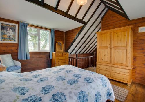 a bedroom with a bed in a room with wooden walls at The Studio in Northrepps