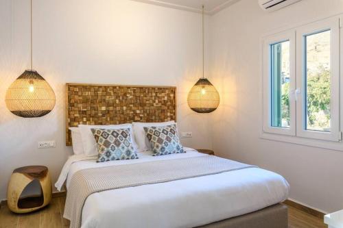 a bedroom with a large bed with two lamps at Blueisla Sea View Suite A in Mikonos