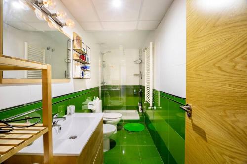 a bathroom with two toilets and a green floor at Apartamento cerca del hospital Virgen de la Arrixaca in Murcia