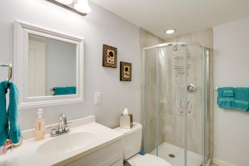 a white bathroom with a shower and a sink at Empire Vacation Rental with Fire Pit and Gas Grill! in Empire