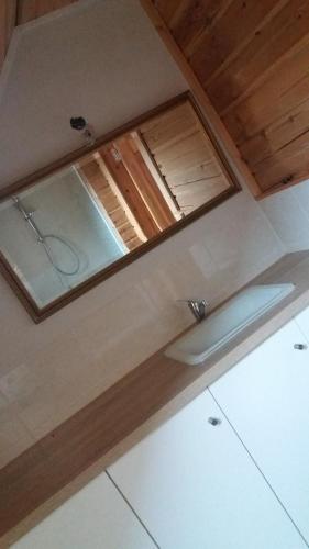une salle de bain avec un miroir au sommet d'une pièce dans l'établissement Au bord du lac III, à Montigny-en-Morvan